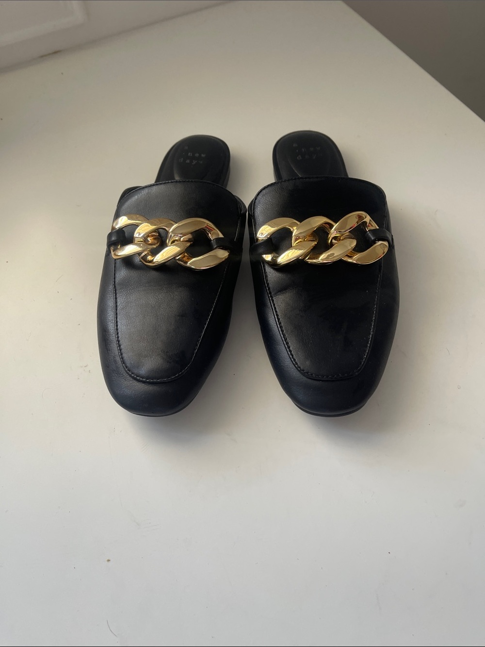 A Nee Day Black Slip-On Loafers with Gold Chain Accent